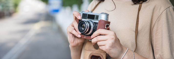 young woman holding vintage camera in the  street