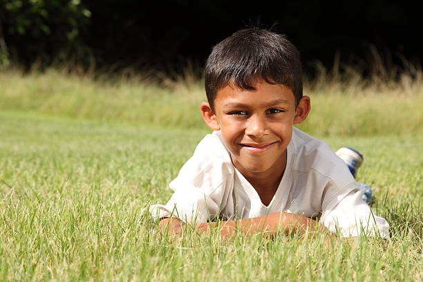 istock Young ethnic boy lying on the grass in park 147918373