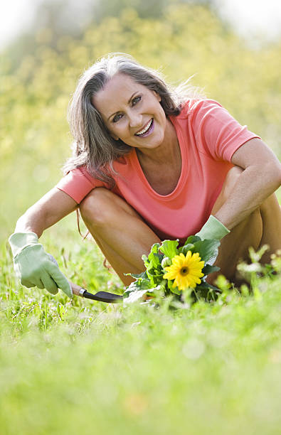 sênior mulher sorridente, sentado ao ar livre - planting clothing gray hair human age - fotografias e filmes do acervo