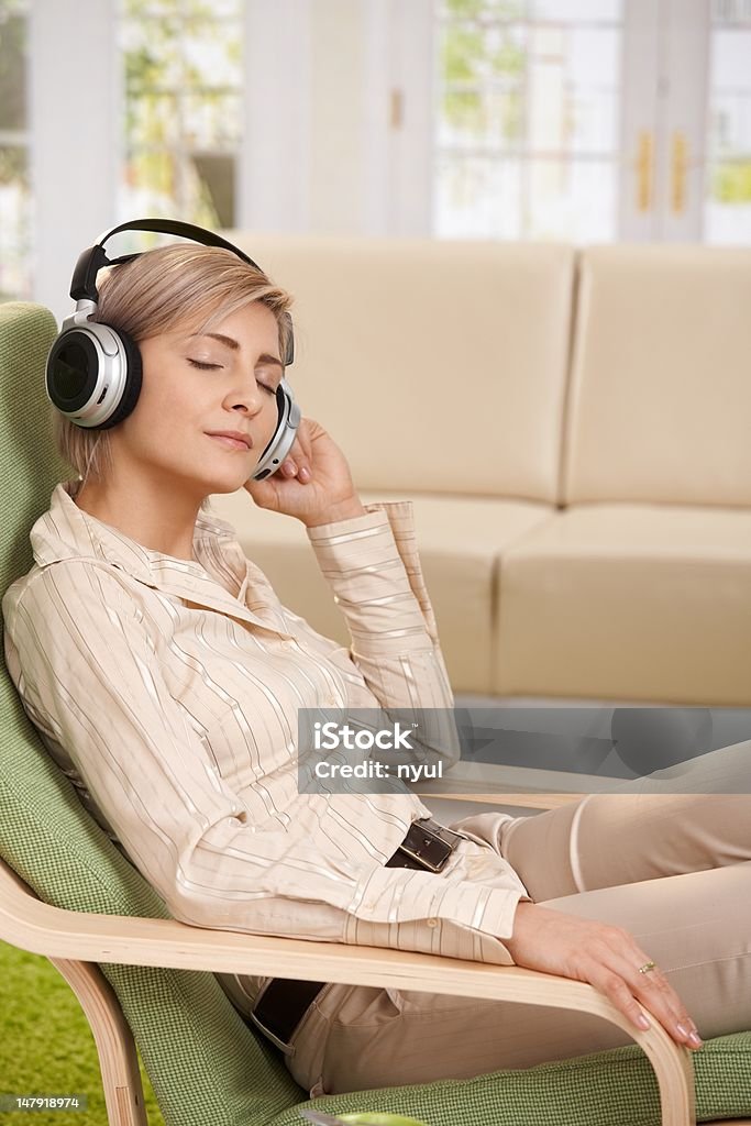 Donna ascoltando la musica a casa - Foto stock royalty-free di Cuffia - Attrezzatura per la musica