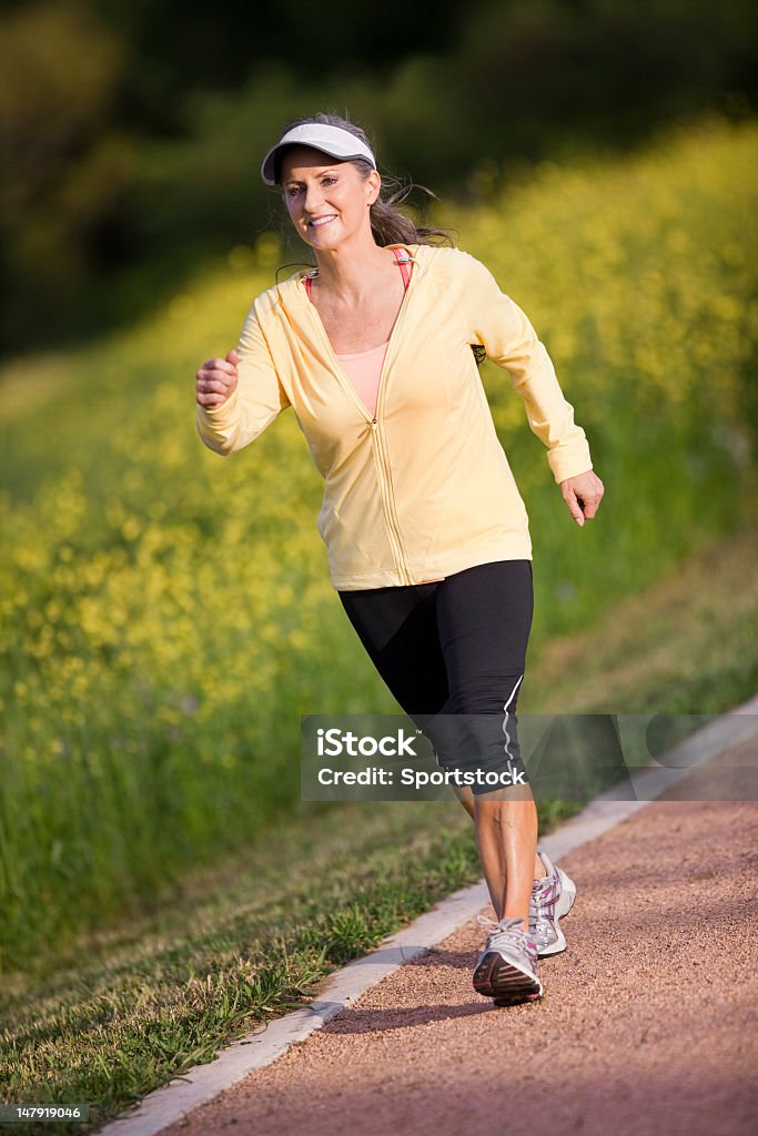 Medio invecchiato donna camminare sul sentiero - Foto stock royalty-free di Camminare