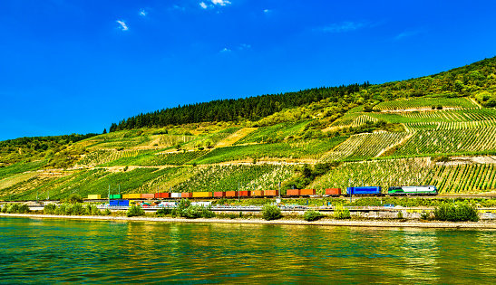 Freight container train at the Rhine River in the Rhine Gorge in Germany