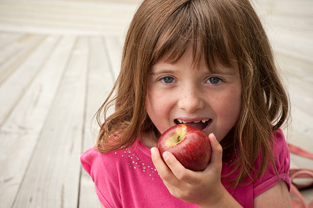 istock little girl eating red apple 147919591