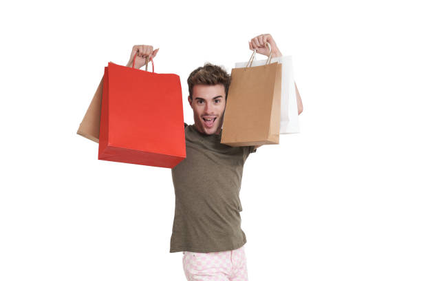 Young caucasian man super happy holding shopping bags, isolated. stock photo
