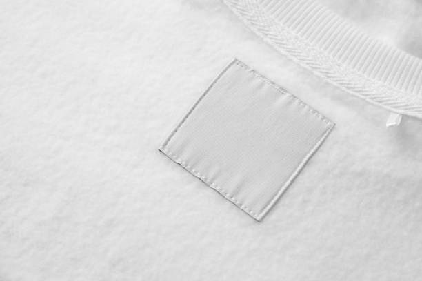 Blank white laundry care clothes label on fabric texture background