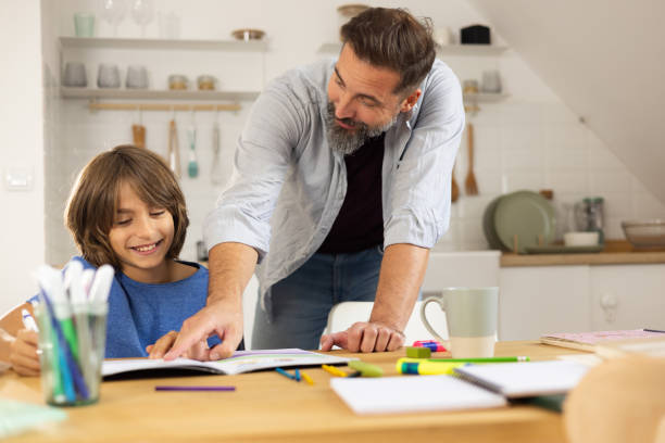 istock Father enjoying morning coffee and helping his little son with homework 1479200132