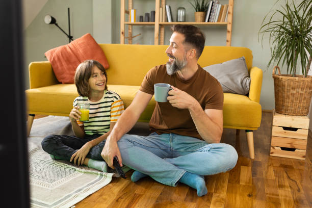 istock Father and son enjoying at home and watching TV 1479200207