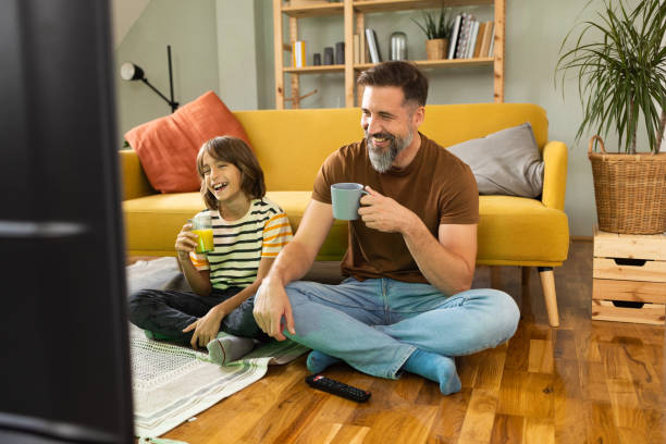 istock Boy watching TV with his dad at home 1479200210
