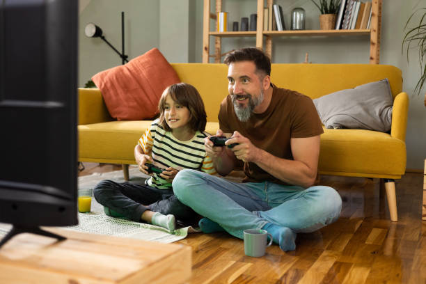 Gather and son playing video games and enjoying at home
