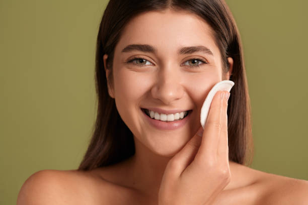 happy young woman cleansing face - cotton smooth green plant imagens e fotografias de stock