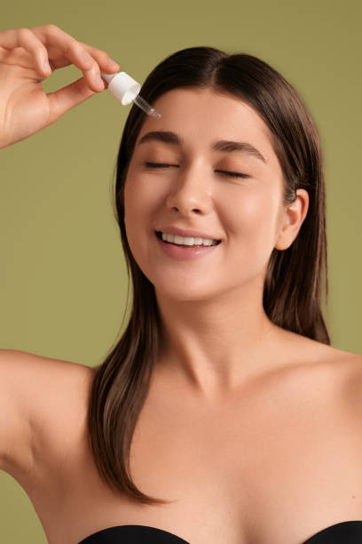 istock Young woman applying cosmetic product on face 1479201521