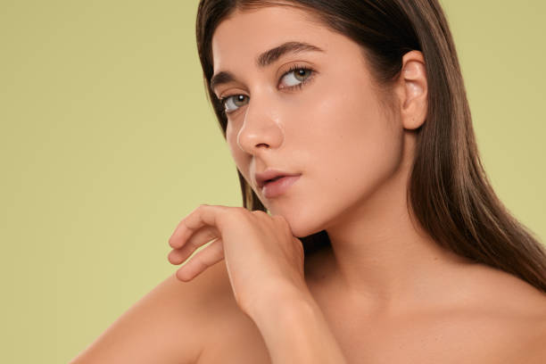 istock Confident young lady touching chin in green studio 1479201523