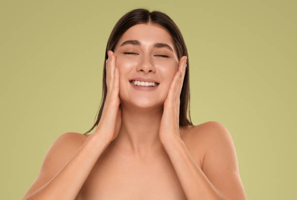 istock Delighted young lady smiling with closed eyes while applying beauty product 1479201538
