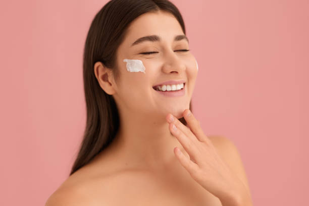 istock Happy young female with cream on cheek 1479201603