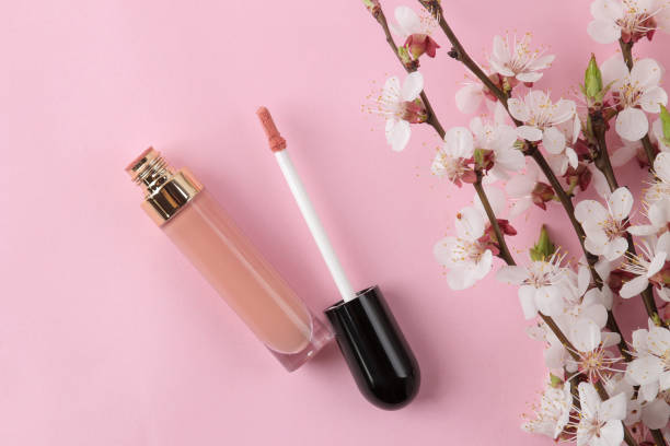 istock Flowering branch. Spring flowers and lipgloss on a bright pink background. top view. 1479202050
