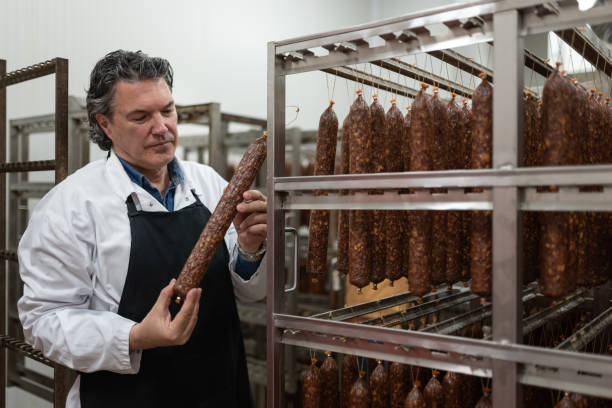 kontrollarbeiter in einem trockenfleischlager - butchers shop meat sausage store stock-fotos und bilder