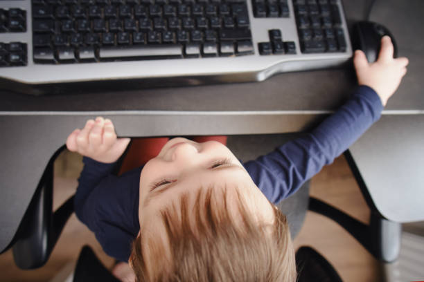 istock Toddler baby works on a computer with a keyboard and mouse. Happy child sits on a computer chair next to the PC. Kid age one year nine months 1479211870