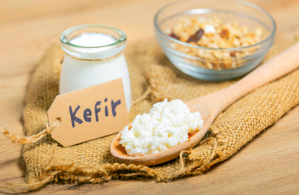 Kefir grains in wooden spoon in front of cups of Kefir Yogurt Parfaits. Kefir is one of the best health foods available providing powerful probiotics. stock photo