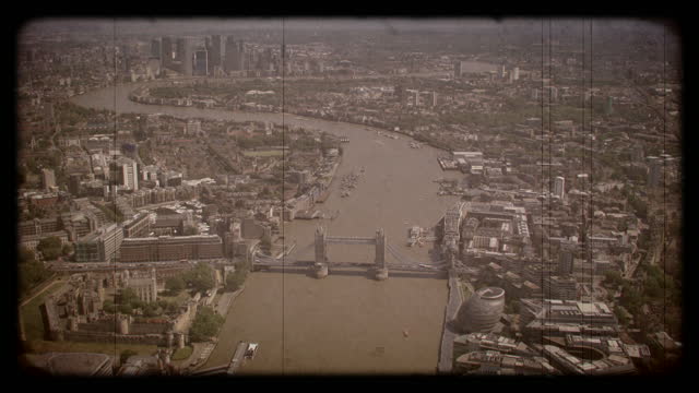 Old Film Aerial View of Tower Bridge and Canary Wharf, London, UK. 4K
