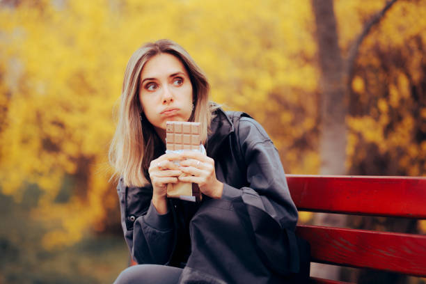 Stressed Woman Eating a Large Chocolate by Herself stock photo