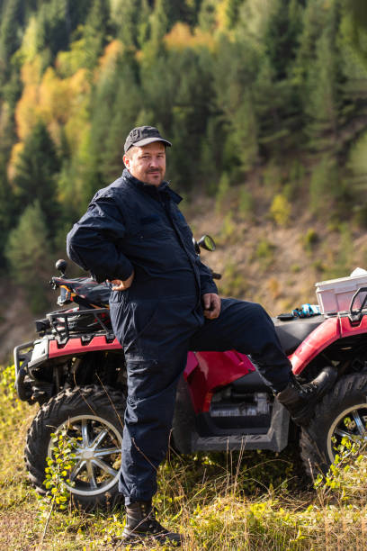 istock A man in a forest area posing next to a quad and preparing for ride 1479225259