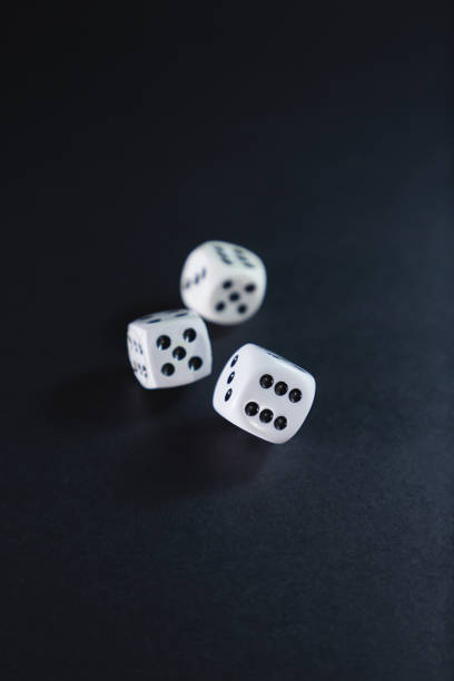 istock Three dice rolled on the table, on a black background with orange reflections. Casino concept,night,roulette,money - selective approach,details. 1479229633