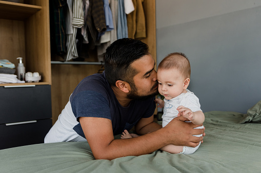 latin Loving father embracing his cute baby son in Mexico Latin America, hispanic family