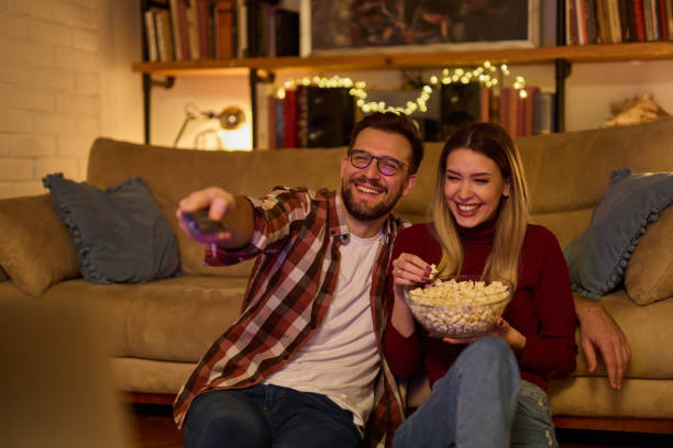 istock Young romantic couple watching TV at home 1479259183