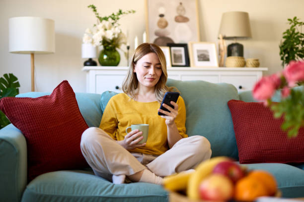 istock Woman using smartphone while drinking coffee at home in the morning 1479260180