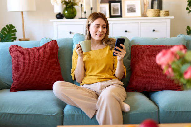 istock Woman using smartphone while drinking coffee at home in the morning 1479260220