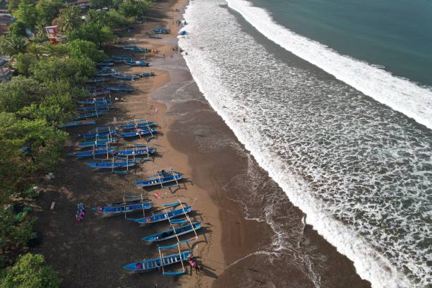 vista aérea de barcos de pesca ancorados na costa. a indonésia é o maior país marítimo do mundo que produz muitas capturas de peixe do oceano. kapal nelayan pantai pangandaran. vista aérea da costa. praia de areia cinza marrom. - sandy brown bay beach sand - fotografias e filmes do acervo