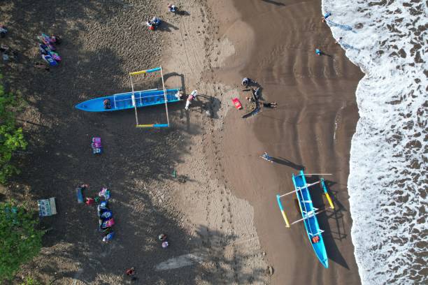 vue aérienne des bateaux de pêche ancrés sur le rivage. l’indonésie est le plus grand pays maritime du monde qui produit beaucoup de prises de poisson dans l’océan. kapal nelayan pantai pangandaran. vue aérienne du rivage. plage de sable gris bru - sandy brown bay beach sand photos et images de collection