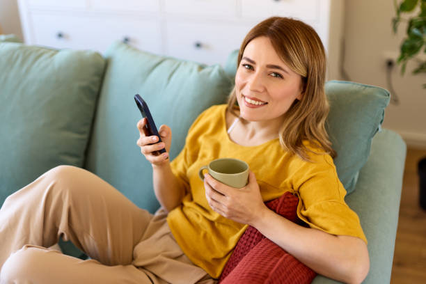 istock Woman using smartphone while drinking coffee at home in the morning 1479260241