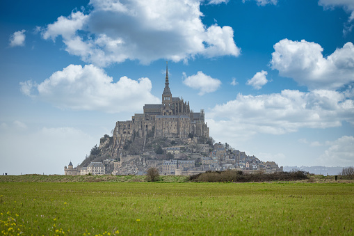 Mont Saint-Michel on tidal Island under sunny summer skyscape. View from the normandy land side towards Mont Saint Michel at the Normandy Coast. Mont Saint-Michel, Avranches, Manche, Normandy, France, Europe