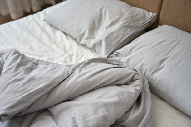 istock Crumpled bed with pillows, blanket and crumpled sheets in bedroom 1479275294