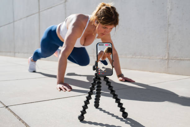 Frau filmt sich selbst mit dem Handy und streamt ihr Fitness-Workout live in den sozialen Medien – Foto
