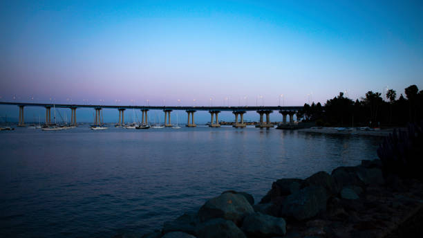 вид через залив на мост в сумерках, мост коронадо, сан-диего - coronado bay bridge стоковые фото и изображения