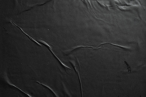 Black paper glued on a wall