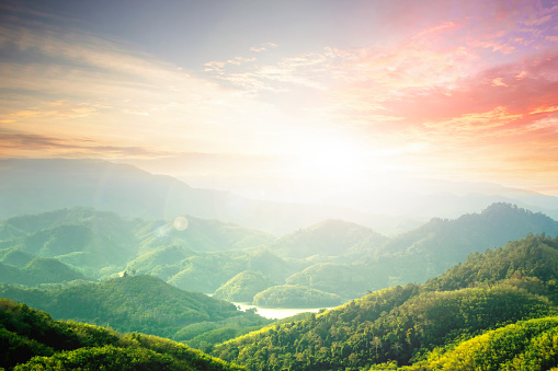 world environment and earth day, sun's rays through the clouds in the mountains at sunset