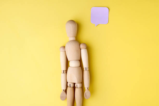 istock Wooden mannequin on a yellow background with thoughts, copy space 1479281656