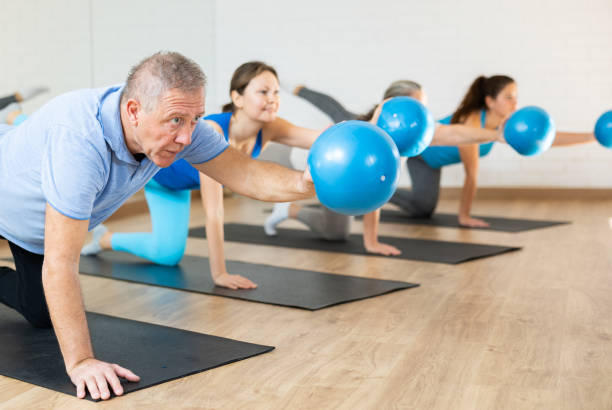 istock Senior man exercising with bender ball during group pilates class 1479284111