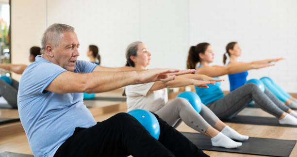 istock Senior man doing sit-ups with pilates ball at gym 1479284139