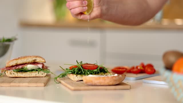 Human hand squeezes lemon on vegan sandwich. Vegan home made food concept