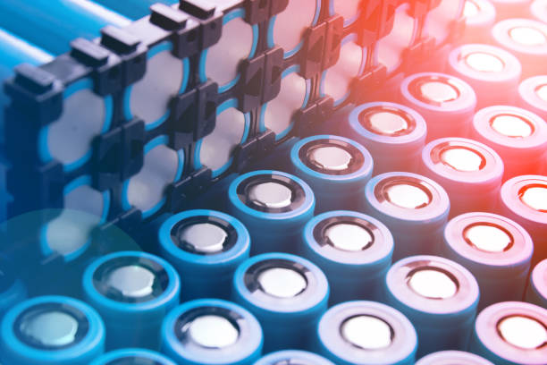 An artistic image of 18650 cells, split diagonally with the lower right corner showcasing densely arranged cells with positive contacts facing up, and the upper left corner displaying cells in holders with negative contacts visible. The image has an artistic glare effect and is toned in complimentary colors. Perfect for technical and scientific projects. una imagen artística de 18650 celdas, dividida diagonalmente con la esquina inferior derecha que muestra celdas densamente dispuestas con contactos positivos hacia arriba, y la esquina superior izquierda que muestra celdas en soportes con contactos negati