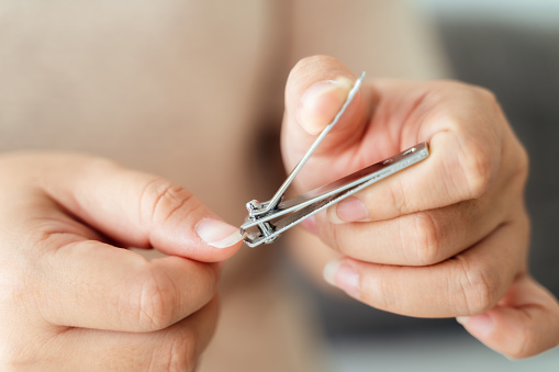 Woman cutting fingernails using nail clipper, Healthcare, Beauty Concept.