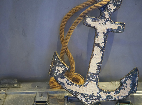Peeling iron anchor with old paint with rope