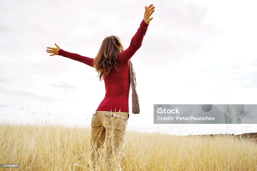 Greeting the new day Young girl spreading hands with joy and inspiration facing the sun Spreading Stock Photo
