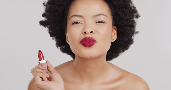 Beauty face, portrait and black woman with red lipstick product for studio skincare, luxury cosmetology or facial cosmetics. Makeup pucker, spa salon or aesthetic afro girl isolated on grey background