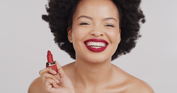 Beauty face, laughing and black woman with red lipstick product for studio skincare, luxury makeup and cosmetics. Cosmetology portrait, spa salon and aesthetic afro girl isolated on grey background