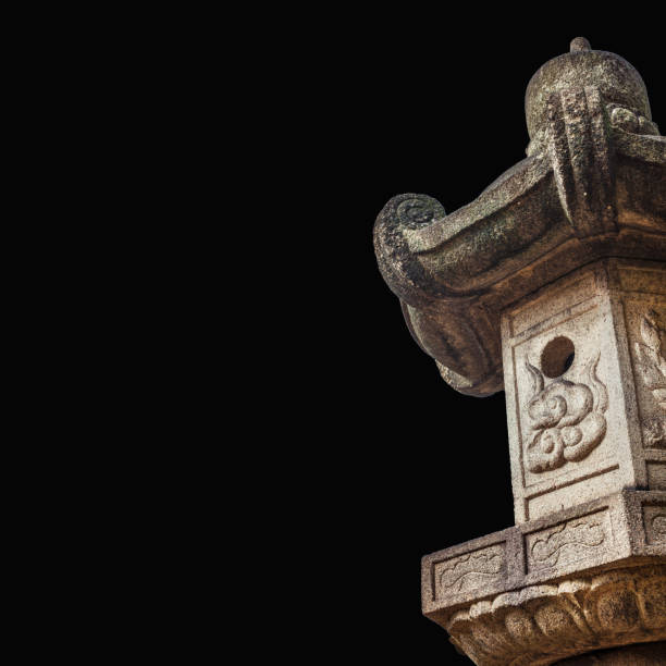 Weathered stone lantern stands serenely amidst a vibrant green landscape, evoking a sense of tranquility and traditional japanese aesthetics